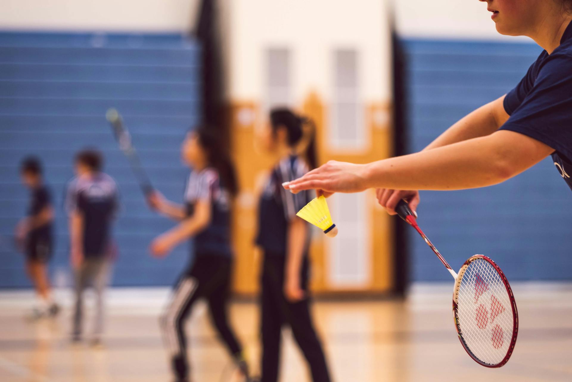 Badminton player, holding shuttlecock, Service position.